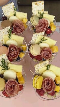 two wine glasses filled with different types of cheese and crackers on top of a table