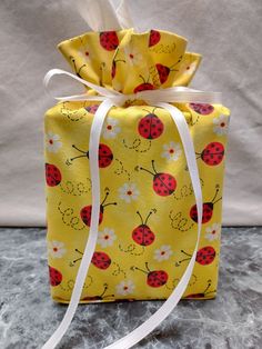 a yellow bag with ladybugs and daisies on it