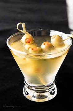 a martini with olives in it sitting on a table