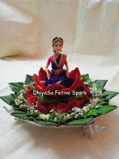 a small figurine sitting on top of a flower arrangement