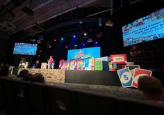 the stage is set up for an event with people playing video games on large screens