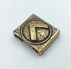 a gold colored metal buckle with the letter f on it's center and bottom