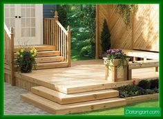 a wooden deck with planters and flowers on it