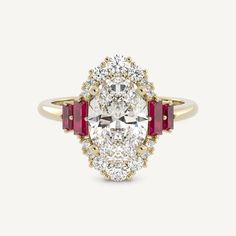 an oval shaped diamond and ruby stone ring with three stones on the band, set in yellow gold