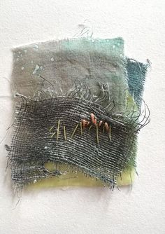 two pieces of fabric with pins sticking out of the top and one piece of thread on the bottom