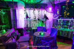 a living room filled with furniture covered in purple and green lights at the end of it