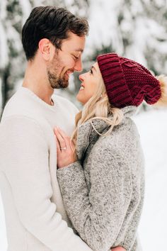 a man and woman standing in the snow together