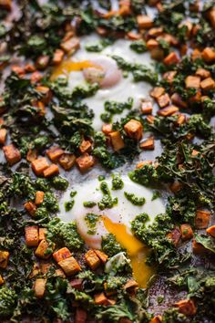 an egg is being fried on top of some broccoli florets and cheese