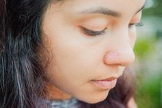 a close up of a person holding a cell phone to their ear and looking down