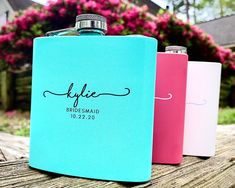 two flasks are sitting next to each other on a wooden table with flowers in the background