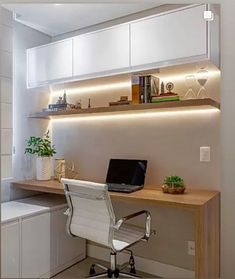 a desk with a laptop on it in front of a wall mounted bookshelf