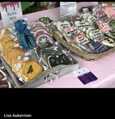 there are many decorated cookies on display at the table with tags in front of them