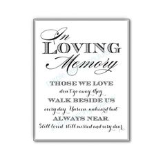 a white framed sign with the words loving memory in black and silver lettering on it