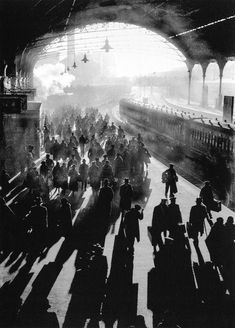 black and white photograph of people walking in train station