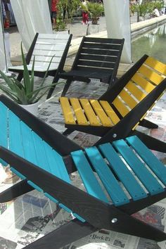 three lawn chairs sitting next to each other on top of a tiled floor near water