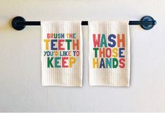 two bathroom towels hanging on the wall next to each other with words that say brush the teeth you're like to keep hands