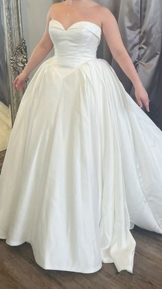 a woman in a white wedding dress posing for the camera