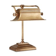 an antique brass desk lamp on a white background