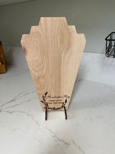 a wooden cutting board sitting on top of a white marble counter next to a wire basket