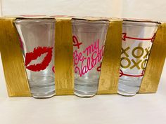 three shot glasses with lipstick painted on them