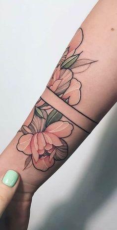 a woman's arm with flowers on it, and the letter e tattooed in black ink