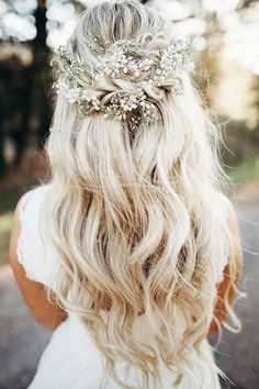 a woman with long blonde hair wearing a flowered headpiece in the middle of her hair