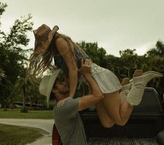 two people in the back of a pick - up truck with their feet on another person's head