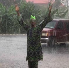 a woman standing in the rain holding her hands up