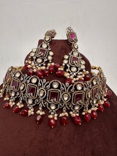 Moissanite Kundan Victorian Mehendi Finish Red Stones and  Red beads Choker with Long Earrings. Sabhysachi Inspired Premium quality Choker. it's a statement choker necklace nice addition to your wardrobe. It's  in Mehendi finish it has copper tone to it. Choker comes with adjust thread(dore) Its a flexible choker fits perfectly on neck. Earrings Length : 3.25 Inches Weight : 20 grams each If you any questions please let me know. Thank you!! Ready to ship from Boston, Massachusetts. Red Ruby Jewelry With Intricate Design, Luxury Red Ruby Jewelry With Intricate Design, Hand Set Red Kundan Ruby Necklace, Festive Red Jewelry With Intricate Design, Traditional Ruby Jewelry Sets With Intricate Design, Bollywood Ruby Jewelry Sets For Festivals, Red Ruby Jewelry For Diwali, Red Ruby Necklace With Tilla Details, Hand-set Red Jewelry For Festive Season