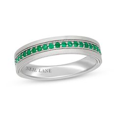 a white gold ring with emerald stones