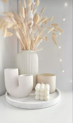 a white vase sitting on top of a table next to candles and marshmallows