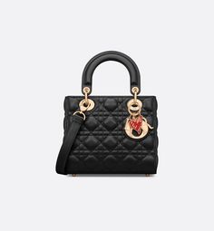 Part of the Dioramour capsule, the Lady Dior bag embodies the House's vision of elegance and beauty. Refined and sophisticated, the timeless style is crafted in black lambskin with Cannage stitching, creating the instantly recognizable quilted texture. The silhouette is elevated by pale gold-finish metal D.I.O.R. charms and a red enamel heart charm. The small Lady Dior bag has a thin, removable leather strap, allowing it to be carried by hand or worn crossbody. It can be coordinated with other D Lady D, Micro Bag, Dior Book Tote, Small Lady, Christian Dior Couture, Wallet Pouch, Backpack Tote Bag, The Lady, Lady Dior Bag