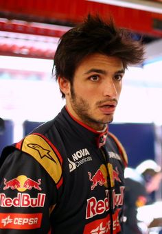 a close up of a person wearing a red bull uniform and looking off to the side