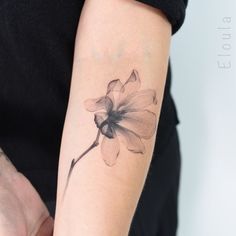 a woman's arm with a flower tattoo on the left side of her arm