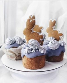 some cupcakes with frosting and bunny ears are on a white cake plate