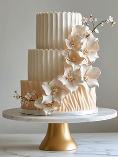 a three tiered cake with white flowers on top