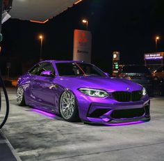 a purple car parked in front of a gas pump