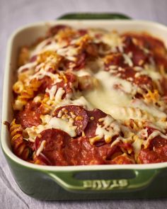 a green casserole dish filled with meat and cheese covered in marinara sauce