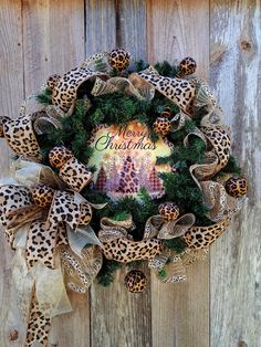 a leopard print christmas wreath on a wooden fence