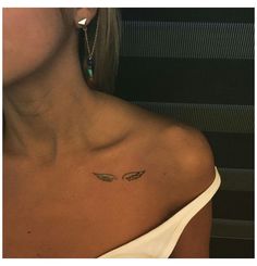 a woman with a small tattoo on her left shoulder and an angel wing in the middle