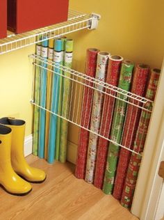 a pair of yellow rain boots sitting on top of a wooden floor next to books