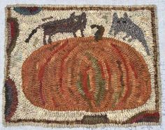 a close up of a rug with animals and pumpkins on the ground in front of it