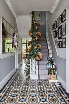 the hallway is decorated for christmas with garland and ornaments on the stairs, along with pictures