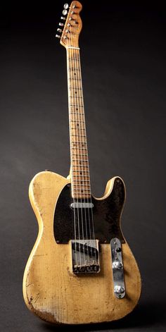 an old guitar sitting on top of a table