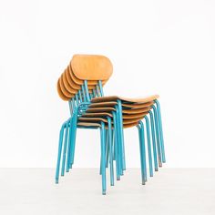 six stacking chairs stacked on top of each other in front of a white wall