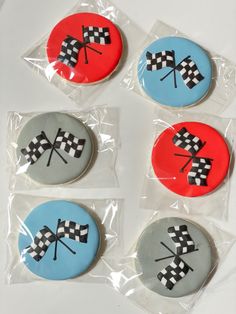 four decorated cookies in the shape of checkered flags