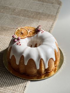 a bundt cake with icing and orange slices sitting on top of a plate