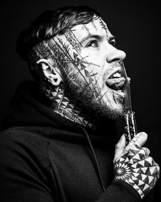 a man with tattoos on his face and neck