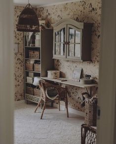 a room with a desk, mirror and shelves filled with baskets on the floor in front of it