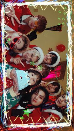 a group of young people standing next to each other in front of a christmas tree